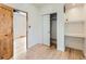 Bedroom with hardwood floors, closet with sliding doors, and built-in shelving with desk at 2849 S Bannock St, Englewood, CO 80110