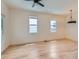 A light and airy empty room with light-colored hardwood flooring and three large windows showcasing natural light at 2849 S Bannock St, Englewood, CO 80110
