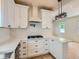 Elegant kitchen featuring white cabinets, bright countertops, and a gas range at 2849 S Bannock St, Englewood, CO 80110