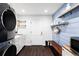 Clean laundry room with modern appliances and bench at 3330 S Columbine Cir, Englewood, CO 80113