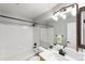 Bathroom with tub and shower featuring white tile, modern black fixtures, and plant at 3529 Huron Peak Ave, Superior, CO 80027