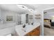 Bathroom featuring double sink vanity, large mirror and lighting with shower and bedroom view at 3529 Huron Peak Ave, Superior, CO 80027