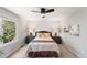 Cozy bedroom featuring a large window, ceiling fan, neutral walls, and beautifully decorated with coordinating bedside lamps at 3529 Huron Peak Ave, Superior, CO 80027