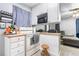 Kitchen with white cabinets, stove, and microwave at 1190 Elmira St, Aurora, CO 80010