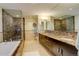 Elegant bathroom featuring a double vanity, soaking tub, and glass-enclosed shower at 191 Clayton Ln # 402, Denver, CO 80206