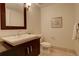 Cozy powder room with dark wood vanity, white sink, and tile flooring at 191 Clayton Ln # 402, Denver, CO 80206