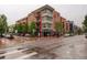 Upscale brick condominium building with modern architectural details on a wet city street at 191 Clayton Ln # 402, Denver, CO 80206