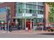Modern restaurant exterior with glass facade, red umbrellas, and outdoor seating for a vibrant dining experience at 191 Clayton Ln # 402, Denver, CO 80206