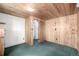 Cozy bedroom features wood-paneled walls and ceiling with carpeting at 7105 Flagstaff Rd, Boulder, CO 80302