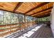 Covered deck has wood railings and ceiling with views of surrounding trees at 7105 Flagstaff Rd, Boulder, CO 80302