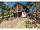 Charming cabin with a large wooden deck surrounded by trees and natural landscape at 7105 Flagstaff Rd, Boulder, CO 80302