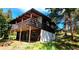 Inviting exterior of the cabin-style home, featuring a spacious deck, surrounded by trees at 7105 Flagstaff Rd, Boulder, CO 80302