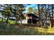 Exterior angle shot of home with deck and porch surrounded by tall trees at 7105 Flagstaff Rd, Boulder, CO 80302