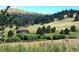 Scenic landscape view of a barn surrounded by lush greenery and a hillside with trees at 7105 Flagstaff Rd, Boulder, CO 80302