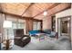 Comfortable living room with wood-paneled walls and ceiling, featuring a fireplace and a view to the outdoors at 7105 Flagstaff Rd, Boulder, CO 80302