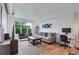 Bright living room with wood floors, windows, couch, and black and white art at 1441 Central St # 209, Denver, CO 80211