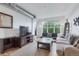 Bright living room with hardwood floors, modern furnishings and a large window overlooking the city at 1441 Central St # 209, Denver, CO 80211