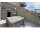 Outdoor patio area featuring a hot tub, privacy walls, and partial views of the city skyline at 1441 Central St # 209, Denver, CO 80211
