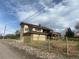 Back exterior showcasing a two-story home with an upper deck and fenced yard at 1123 S Quince Way, Denver, CO 80231