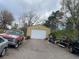An exterior view of a residential home's tan garage featuring a white garage door and cars in the driveway at 1123 S Quince Way, Denver, CO 80231