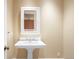 Bathroom features a pedestal sink with a white framed mirror above, creating a classic and clean aesthetic at 465 Monroe St, Denver, CO 80206