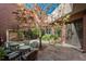 Private courtyard with stone flooring, outdoor dining, fountain, and lush landscaping, creating a serene escape at 465 Monroe St, Denver, CO 80206