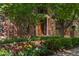 Elegant brick home with beautiful flowers, manicured landscaping and mature trees at 465 Monroe St, Denver, CO 80206
