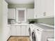 Well-organized laundry room with white cabinets, modern washer and dryer, and a convenient sink area at 465 Monroe St, Denver, CO 80206