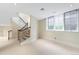 Open staircase featuring iron railings, carpeted steps, and natural light from the large windows at 465 Monroe St, Denver, CO 80206