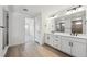 Bathroom featuring dual sinks, white cabinets and black hardware at 7036 E 126Th Pl, Thornton, CO 80602