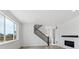 Bright living room with fireplace, staircase, and many windows bringing in natural light at 7036 E 126Th Pl, Thornton, CO 80602