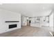 Open floor plan view of kitchen with white cabinetry and a fireplace in the living room at 7036 E 126Th Pl, Thornton, CO 80602