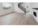 Bright living room featuring light wood floors, staircase and fireplace at 7036 E 126Th Pl, Thornton, CO 80602