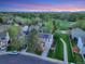 Aerial view showcasing a well-kept home with solar panels, lush lawn, and greenbelt access with mountain views at dusk at 4347 W Kenyon Ave, Denver, CO 80236
