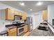Modern kitchen with stainless steel appliances, granite countertops, and ample cabinet space at 4347 W Kenyon Ave, Denver, CO 80236