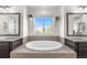 Serene bathroom showcasing a soaking tub, dual sinks, and natural light from a window at 4009 Manorbrier Cir, Castle Rock, CO 80104