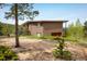 A brick home featuring an attached garage is situated amidst mature trees and greenery at 401 Highway 72, Golden, CO 80403
