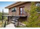Close-up of the home's brick exterior, covered porch, mature trees, and well-manicured landscaping at 401 Highway 72, Golden, CO 80403