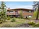 Charming brick home with a well-maintained lawn, front porch, and mature trees creating a peaceful setting at 401 Highway 72, Golden, CO 80403