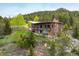 Stunning home with brick and stone exterior, surrounded by lush greenery and mature trees on a large lot at 401 Highway 72, Golden, CO 80403