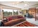 Comfortable living room with plush brown sofa, stone wall accent, and scenic outdoor views at 401 Highway 72, Golden, CO 80403