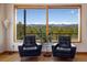 Living room featuring two armchairs that face a gorgeous mountain view through a large picture window at 401 Highway 72, Golden, CO 80403