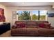 Cozy living room featuring a plush brown sofa and expansive window views of the natural landscape at 401 Highway 72, Golden, CO 80403