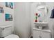 Stylish powder room with a pedestal sink, decorative mirror, and modern fixtures at 18304 Caffey Dr, Parker, CO 80134