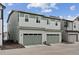 Two-story townhome featuring two garages, and neutral siding with green accents at 18304 Caffey Dr, Parker, CO 80134