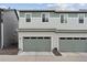 Charming two-story townhome featuring two garages, with neutral siding and green accents at 18304 Caffey Dr, Parker, CO 80134