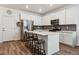 Bright kitchen features stainless steel appliances, white cabinetry, gray backsplash and bar stool seating at 18304 Caffey Dr, Parker, CO 80134