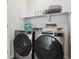 Laundry room featuring modern washer and dryer with storage shelves and supplies above at 18304 Caffey Dr, Parker, CO 80134