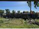 Overgrown backyard, fence and playground behind the house at 841 S 6Th Ave, Brighton, CO 80601