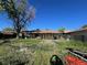 Backyard with covered patio and overgrown lawn at 841 S 6Th Ave, Brighton, CO 80601